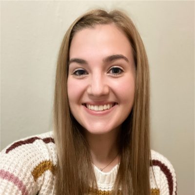 Indoor headshot of student Katelyn Singer in striped sweater against light background